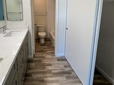A bathroom with a toilet, sink, and tiled floor.