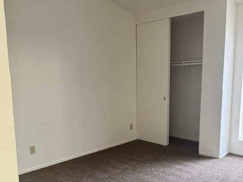 A room with a white door and a carpeted floor.