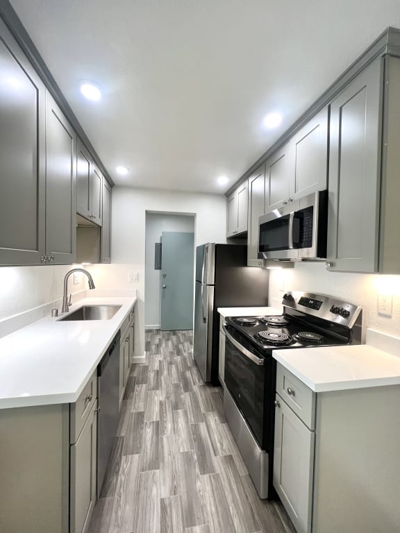 a kitchen with white cabinets and a window