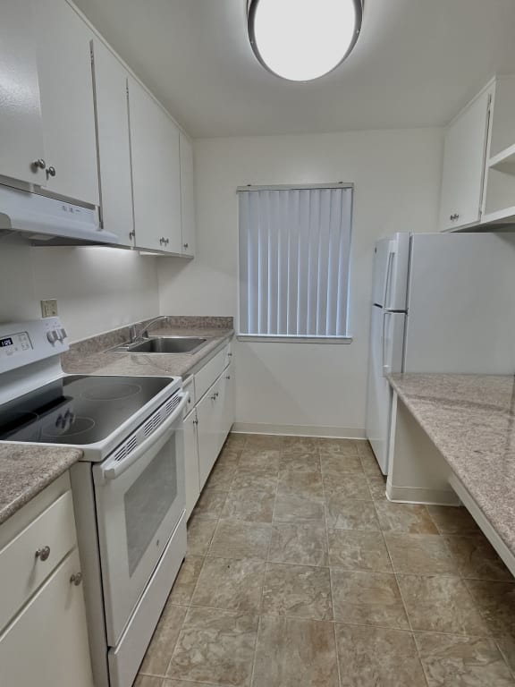 a kitchen with white cabinets and white appliances