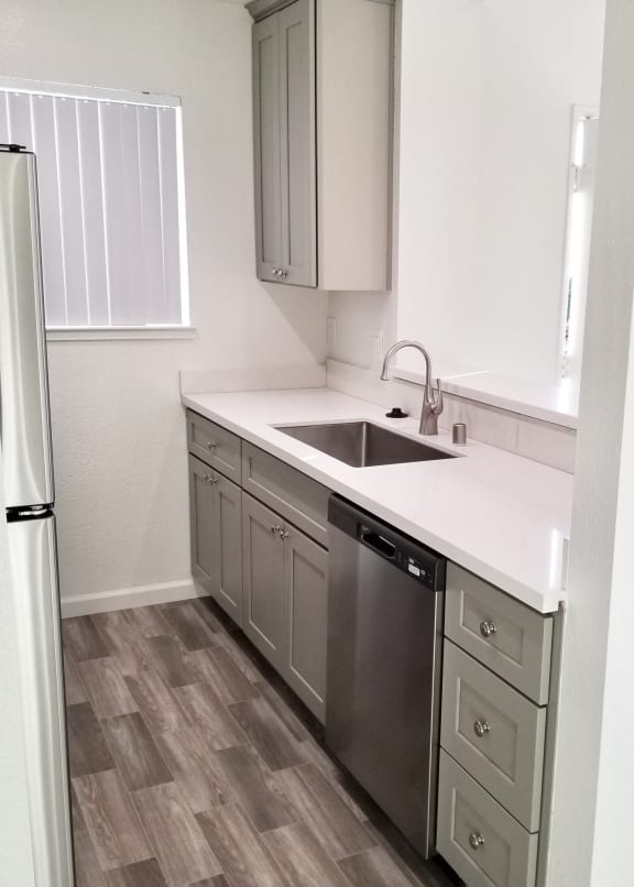an empty kitchen with a sink and a refrigerator