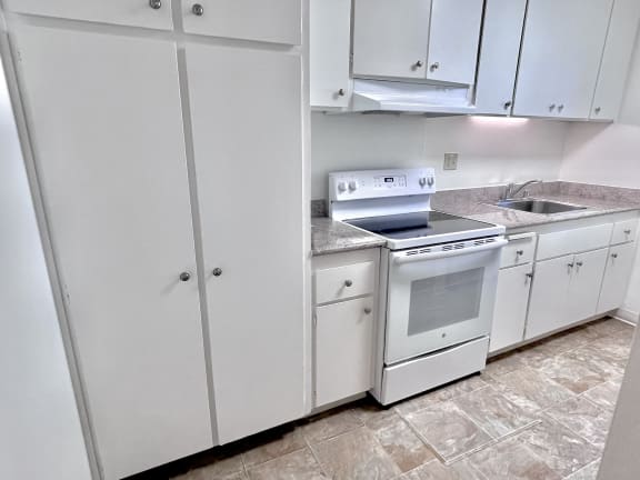 a kitchen with white cabinets and white appliances