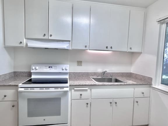 a kitchen with white cabinets and white appliances