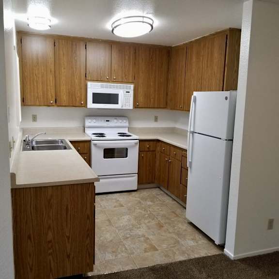 A kitchen with wooden cabinets and white appliances.