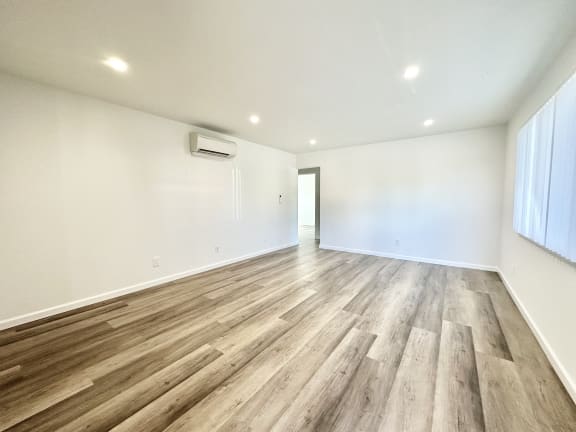 a living room with hardwood floors and white walls