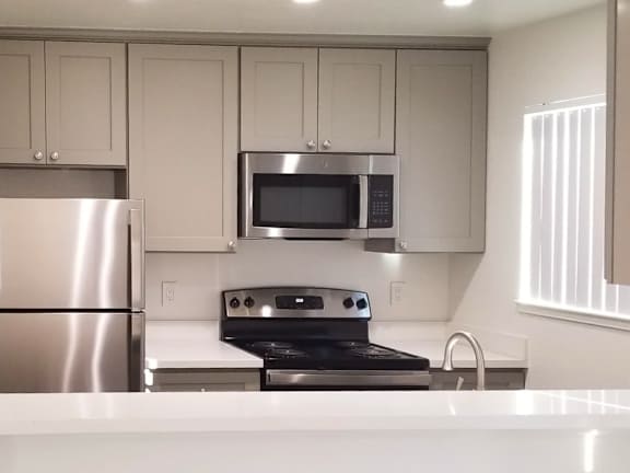 A modern kitchen with stainless steel appliances and white cabinets.