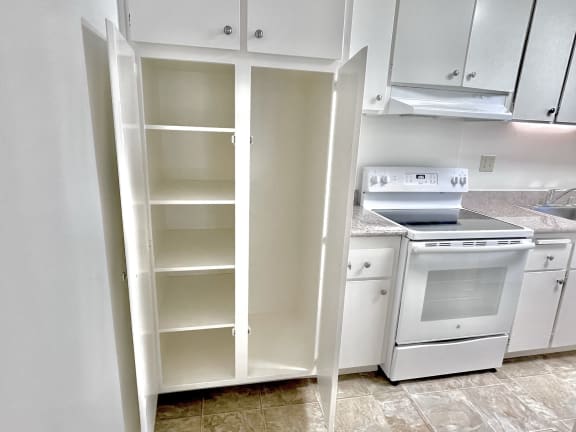 a kitchen with white cabinets and white appliances