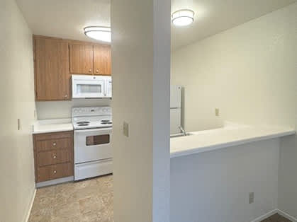 A kitchen with white appliances and wooden cabinets.