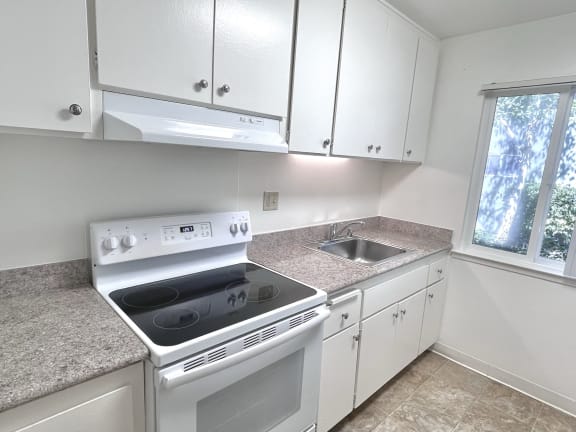 a kitchen with white cabinets and white appliances