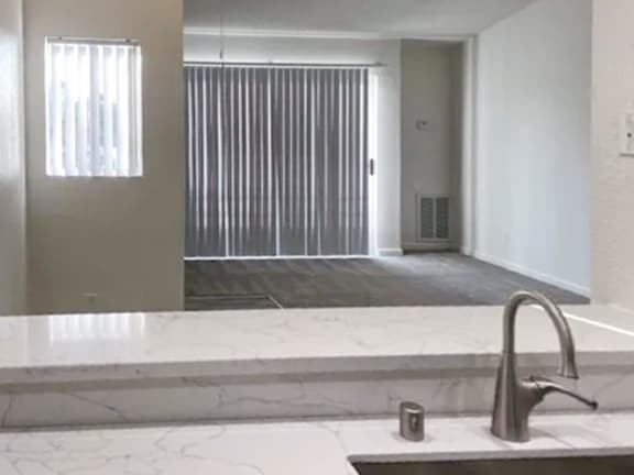 A bathroom with a marble countertop and a modern faucet.