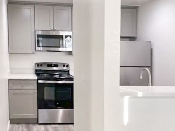 A kitchen with a stove, oven, and refrigerator.