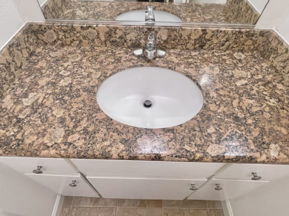 a sink in a bathroom with a granite countertop