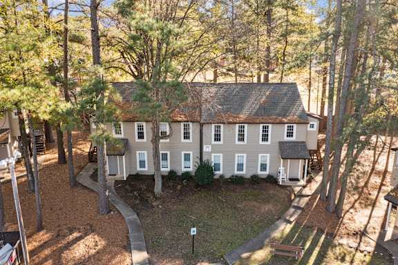 A house surrounded by trees in a forest at West Oak Apartments, Wake Forest, North Carolina