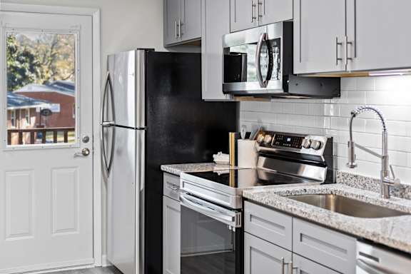 A kitchen with a black fridge and stove at West Oak Apartments, North Carolina 27587