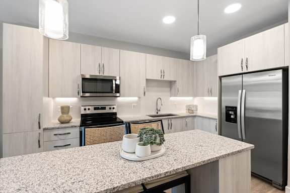 A kitchen with a granite countertop and stainless steel appliances.