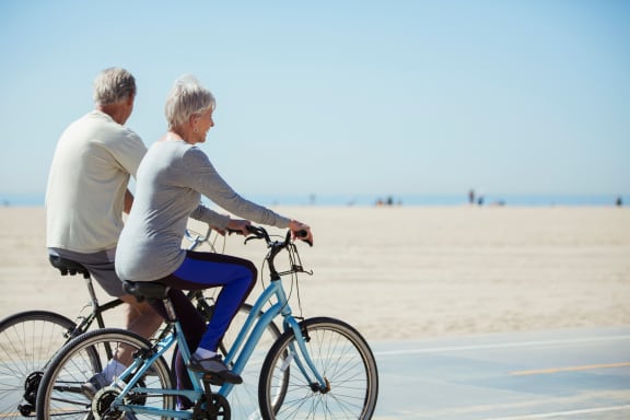 a man and a woman riding bikes on the beach at Mira at Palmer Ranch, Sarasota
