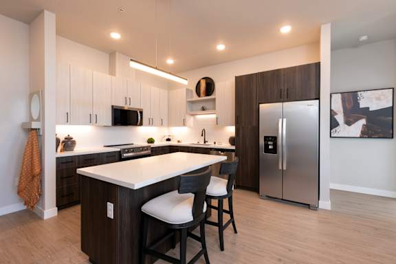 A modern kitchen with a white countertop and stainless steel appliances.
