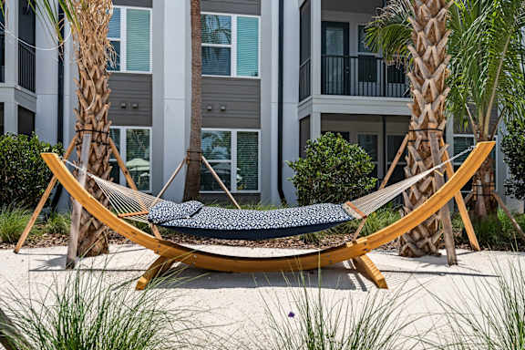 a hammock with apartment balcony in background at Mira at Palmer Ranch in Sarasota, FL
