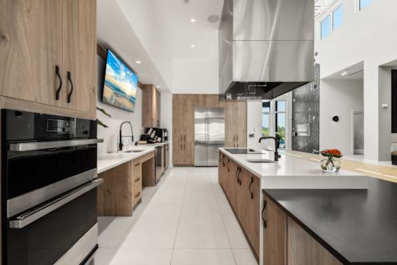 resident lounge demonstration kitchen with wooden cabinets and stainless steel appliances at Mira at Palmer Ranch in Sarasota, FL