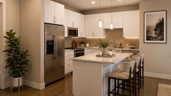A modern kitchen with a refrigerator, microwave, and bar stools.