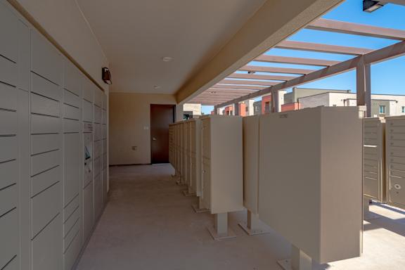 A long hallway with white lockers on the left and a row of white booths on the right.