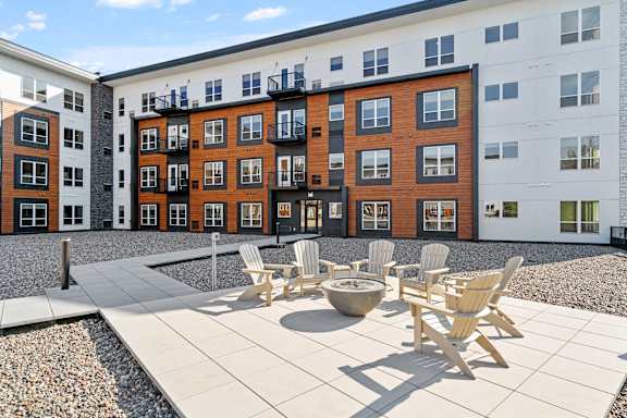 A patio with chairs and a table in front of a building.