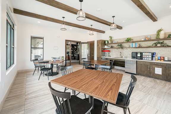 A modern kitchen with a wooden table and chairs.