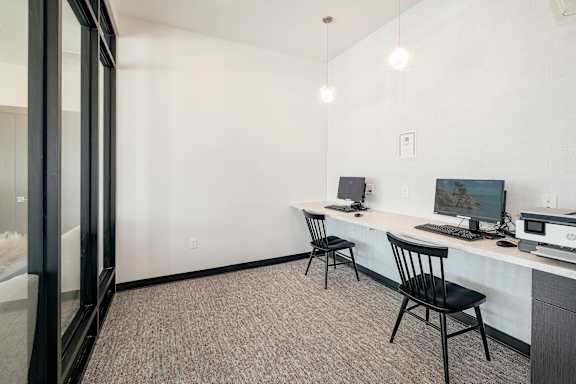 A room with a desk, chair, and computer monitor.