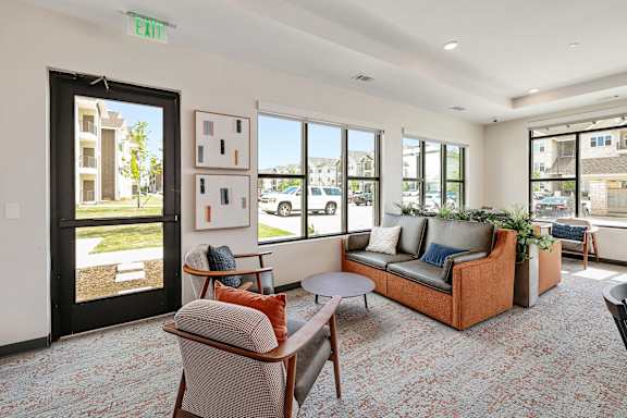 A living room with a couch, chairs, and a rug.