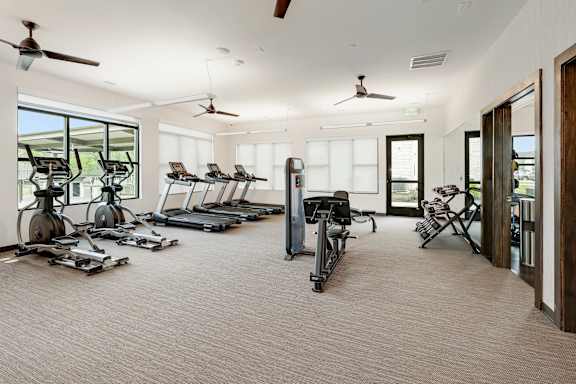 A spacious gym with treadmills, elliptical machines, and other exercise equipment.