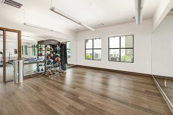A gym with a mirror, weights, and exercise equipment.