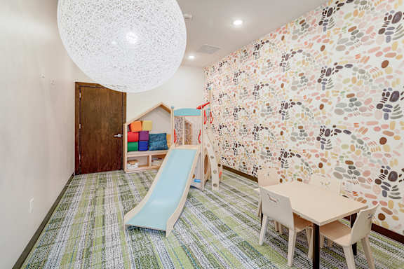 A room with a wall covered in footprints and a slide.