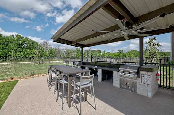 A patio with a table and chairs under a roof.