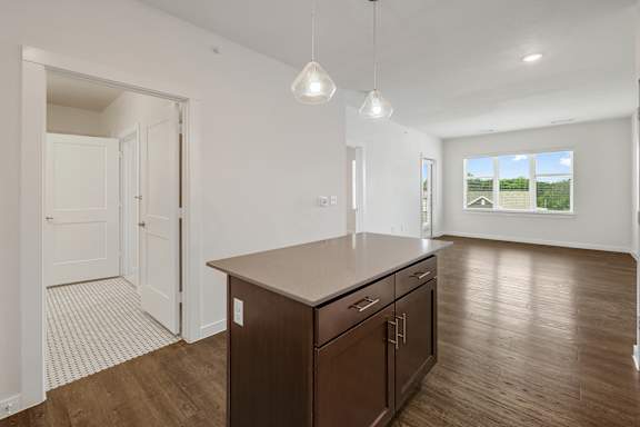 A kitchen with a brown counter top and wooden floors.