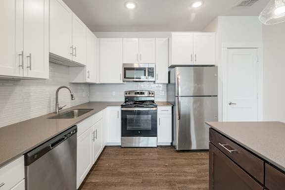 A modern kitchen with stainless steel appliances and white cabinets.