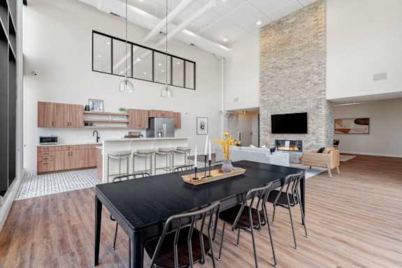 A modern kitchen with a black table and chairs.
