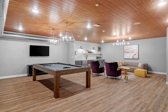 A room with a pool table and a television.