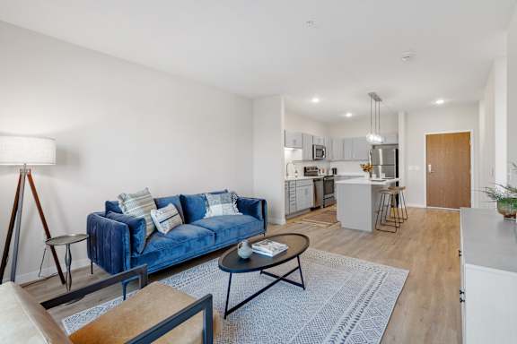 A blue couch is in the middle of a living room.