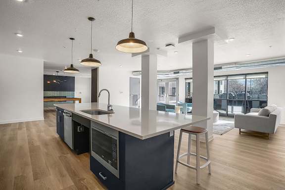 A modern kitchen with dark blue cabinets and wooden floors.