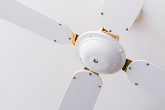 a close up of a white ceiling fan