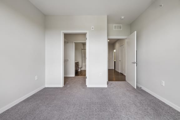 an empty living room with white walls and carpet