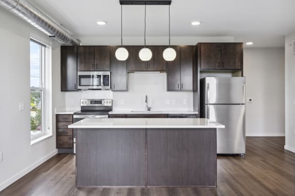 a modern kitchen with stainless steel appliances and dark wood cabinets