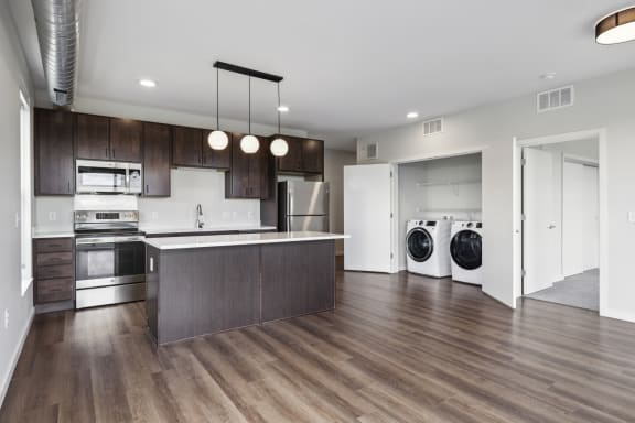 an open kitchen and laundry room with a washer and dryer and a sink