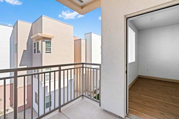 A balcony with a metal railing and a view of other buildings.