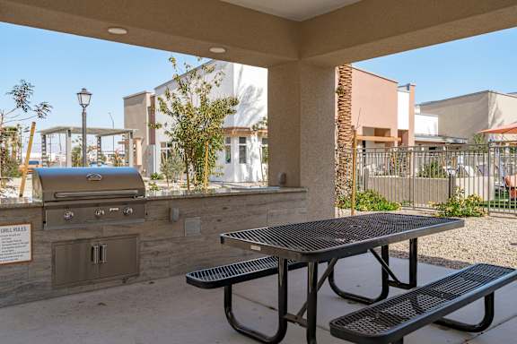 A picnic area with a grill and picnic table.