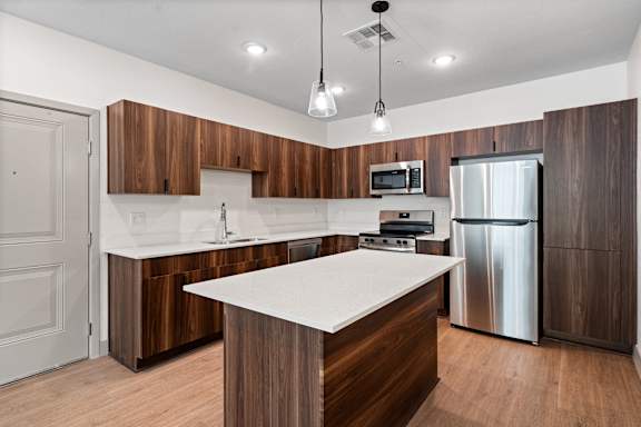 A modern kitchen with wooden cabinets and stainless steel appliances.