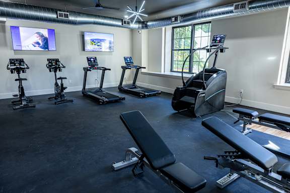 A gym with treadmills, elliptical machines, and a rowing machine.