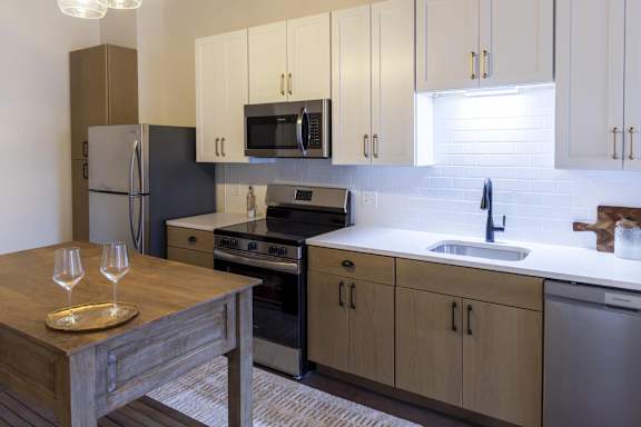 A kitchen with a wooden table and a refrigerator at The Dean at Creekview Apartments, Newark, DE