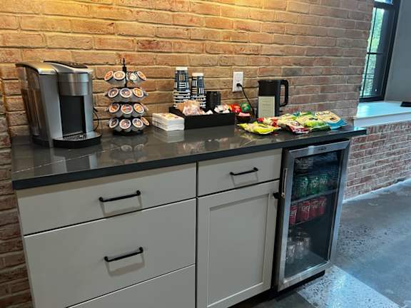 A kitchen with a black countertop and white cabinets.
