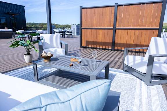 A patio with a table, chairs and a potted plant.